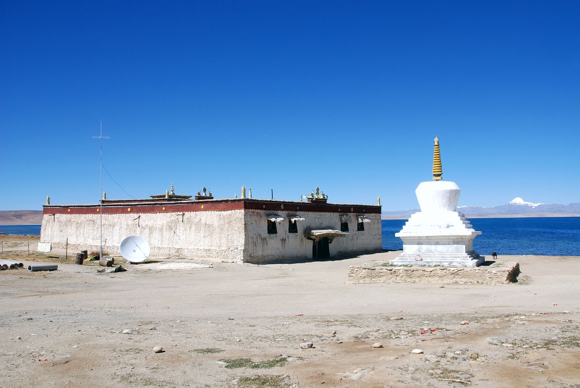 19 Trugo Gompa And Chorten On Lake Manasarovar South Shore With Mount Kailash On the south shore of Lake Manasarovar, the Gelugpa Trugo (Bathing Head) Gompa (4601m) is named for its importance as a place for ritual bathing by Hindus. Hindus immerse themselves totally in the icy water, while Tibetans simply splash water on their heads and drink the water.